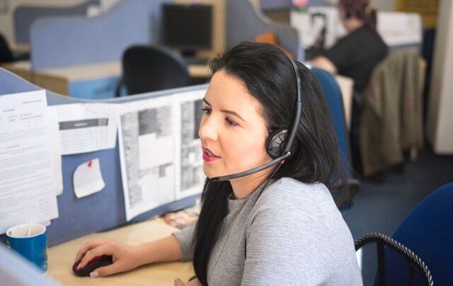 Lady with headset on working on a computer