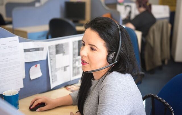 Lady with headset on working on a computer