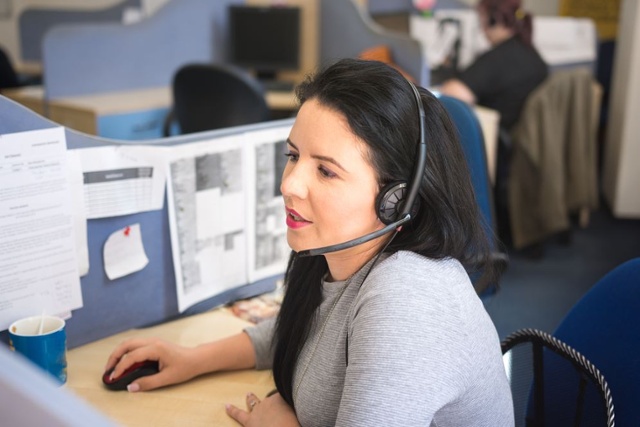 Lady with headset on working on a computer