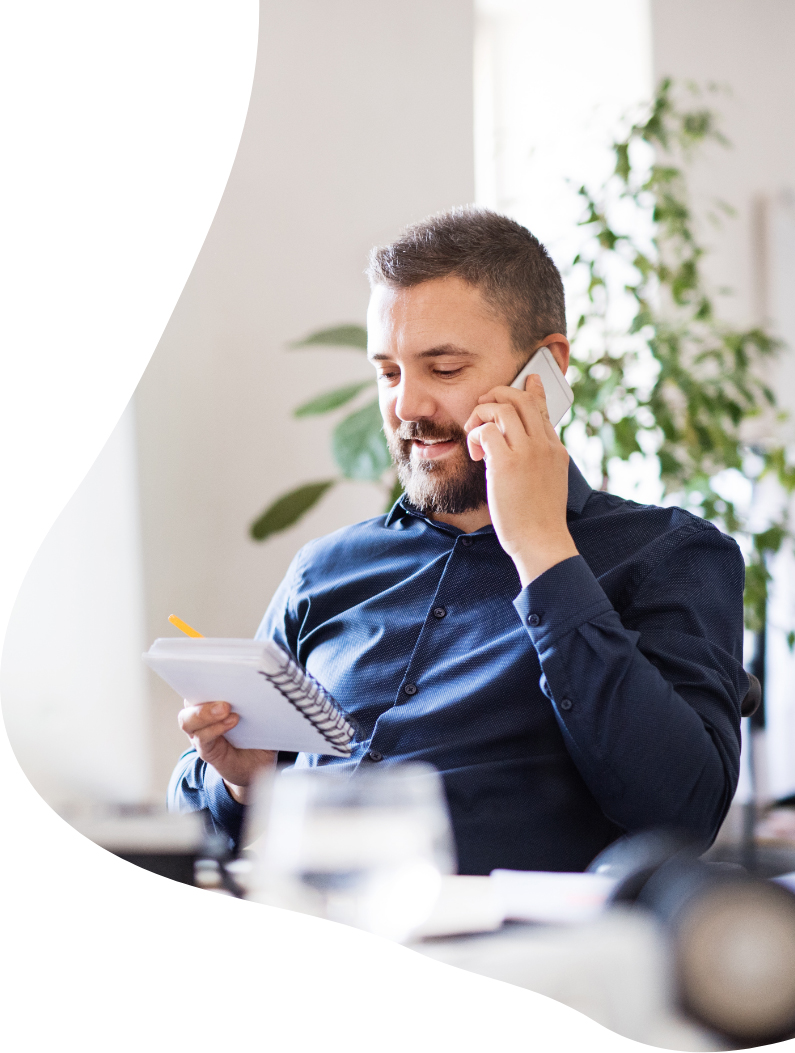 Man holding a notebook whilst on the phone