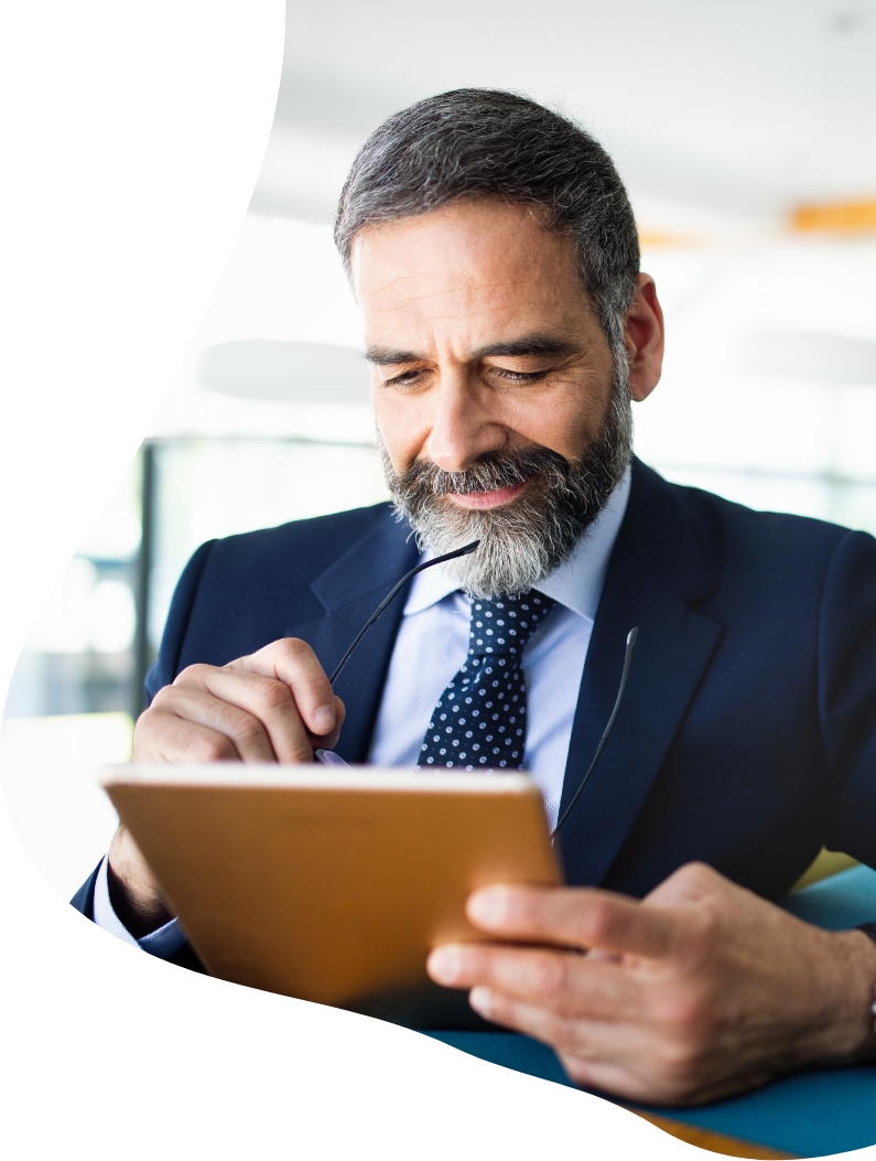 Man wearing a suit looking at an ipad