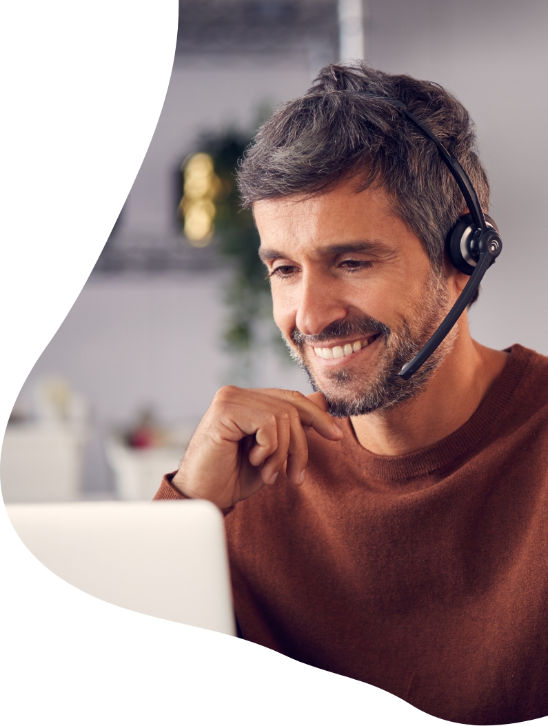 Man on computer with headset smiling